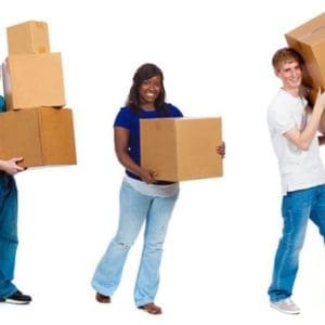 Three people smiling and holding cardboard boxes against a white background. They appear relaxed and casual, wearing jeans and colourful tops. Safe Moving and Handling