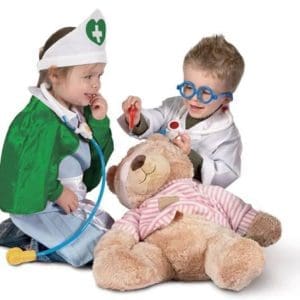 Children dressed as doctors playfully "treat" a stuffed bear with toy tools. They seem engaged and happy, creating a fun and imaginative scene. Paediatric First Aid